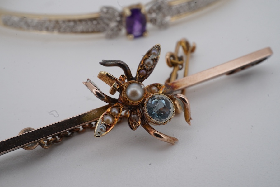 An amethyst and diamond bangle, inner circumference 17.5cm, mounted in gold, gross weight 7 grams; and an Edwardian bar brooch designed as an insect, set with a circular-cut aquamarine and seed pearls, mounted in gold, l